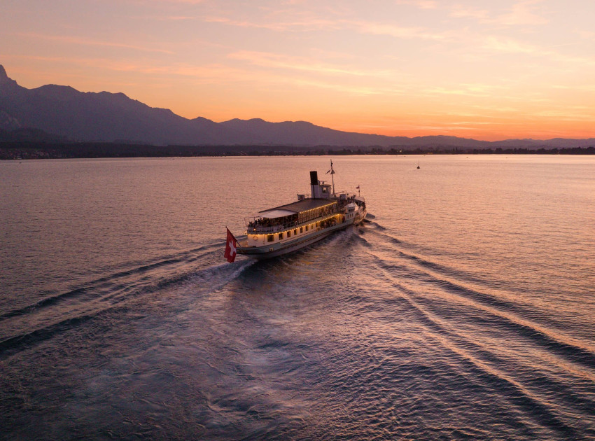 Das Dampfschiff Blümlisalp auf dem Thunersee bei Sonnenuntergang