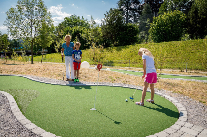 Familie beim Minigolf spielen